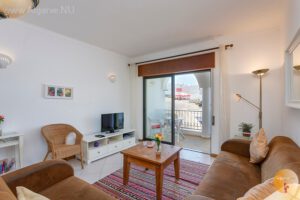 Ruime woonkamer met Nederlandse TV en balkon met uitzicht Carvoeiro